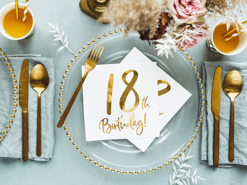 Elegant table setting with white and gold 18th birthday napkins, shipping Canada-wide.