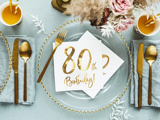Elegant milestone birthday table setting with white and gold 80th birthday napkins, available for shipping across Canada.
