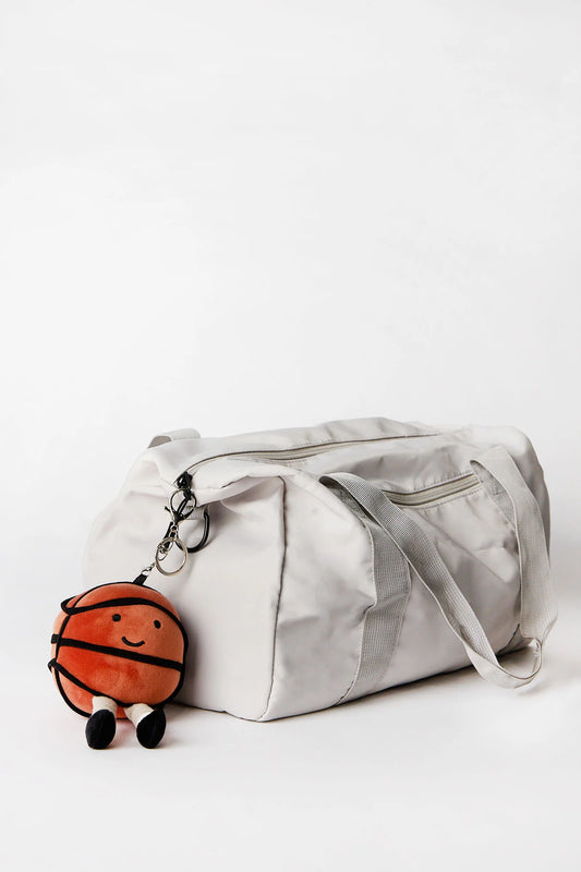 Basketball plush keychain charm clipped onto bag available in Toronto and shipping across Canada