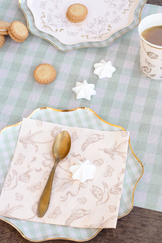 Beige floral napkin styled on table with desserts, available in Toronto and shipping across Canada.