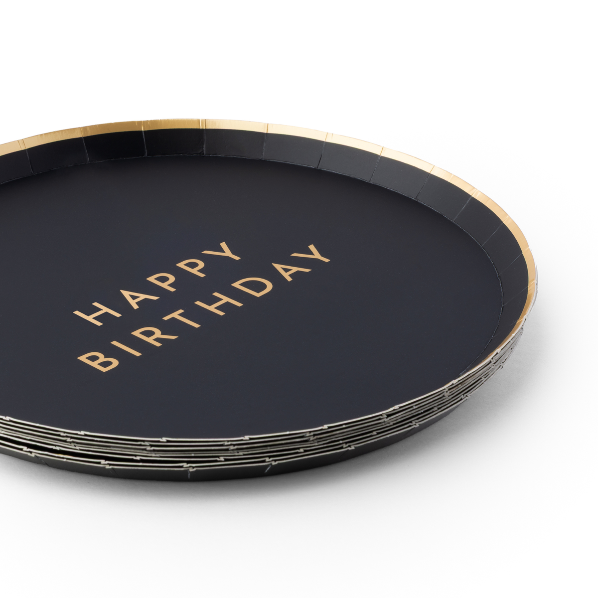Close-up of black birthday plates with Happy Birthday gold foil lettering and gold trim