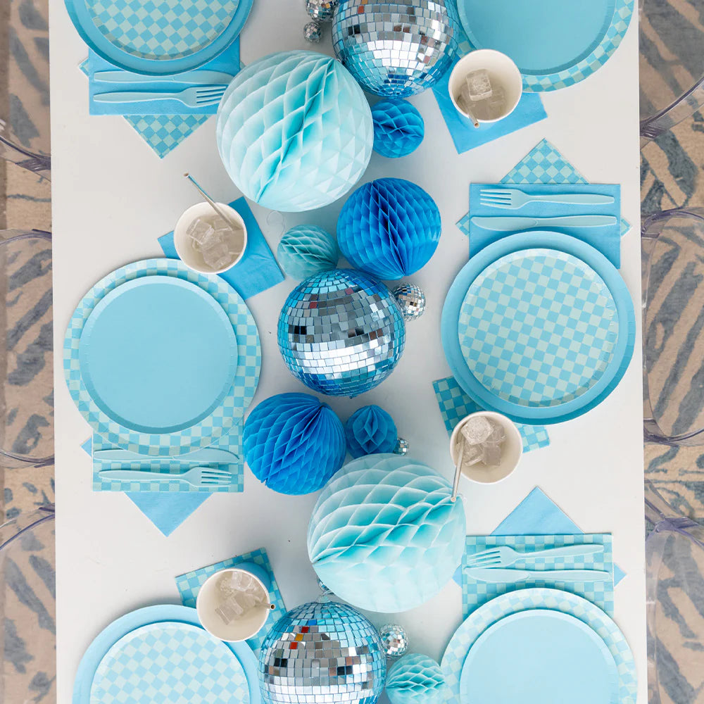 Blue checkered party table setup with matching plates, napkins, cutlery, and disco ball centerpiece.