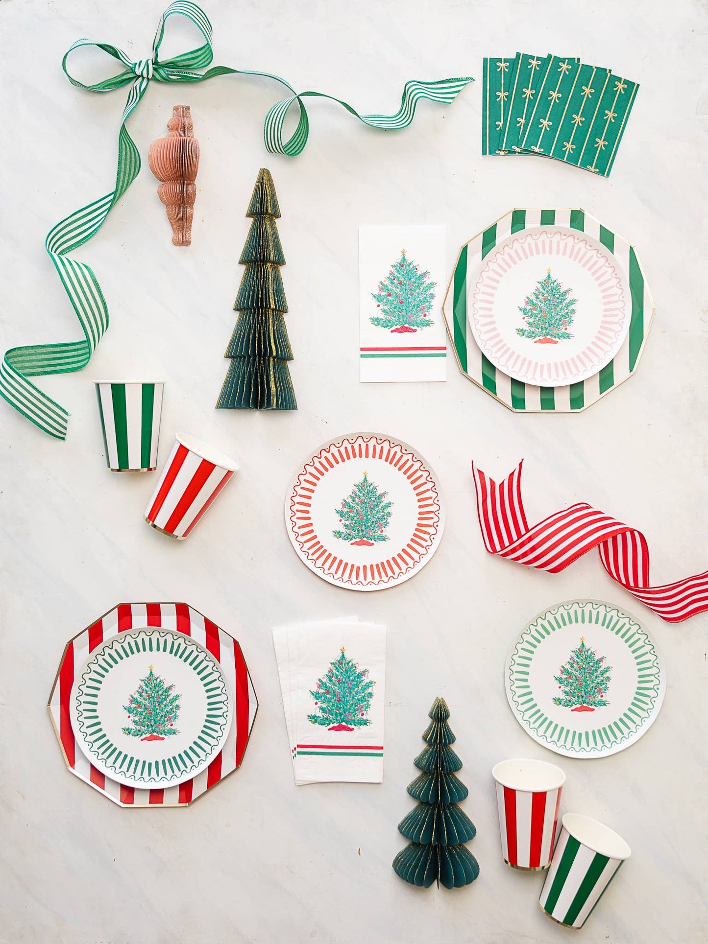 Holiday party flatlay featuring cherry red cabana stripe cups styled with Christmas plates and décor from Confetti My Party Toronto