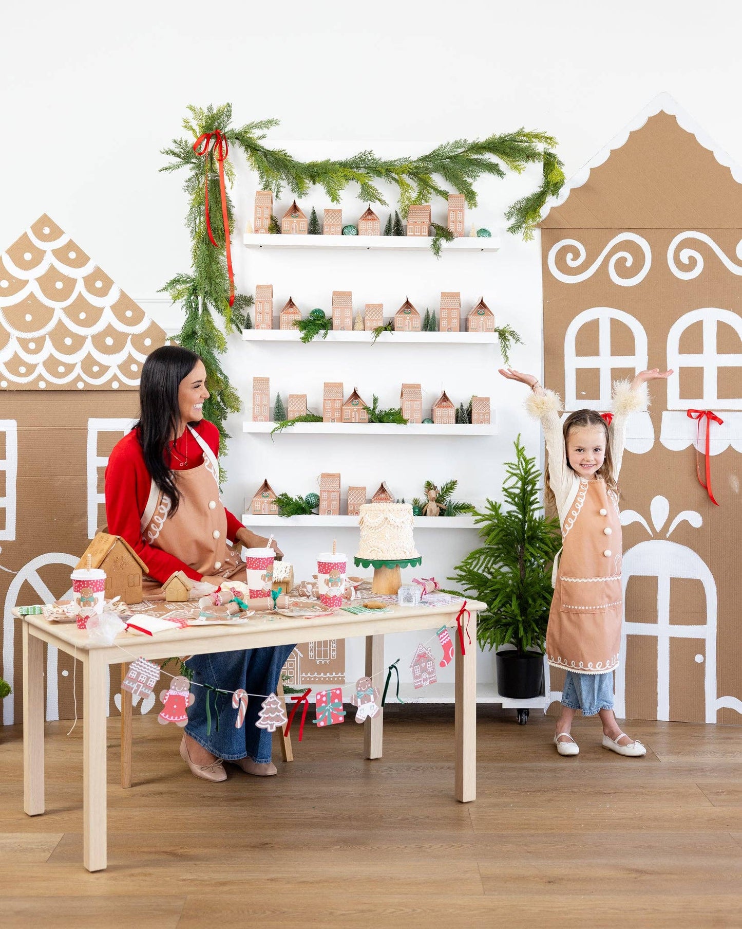 Mom and daughter wearing gingerbread aprons while decorating a Christmas table. Pick up in Toronto and fast shipping Canada-wide.