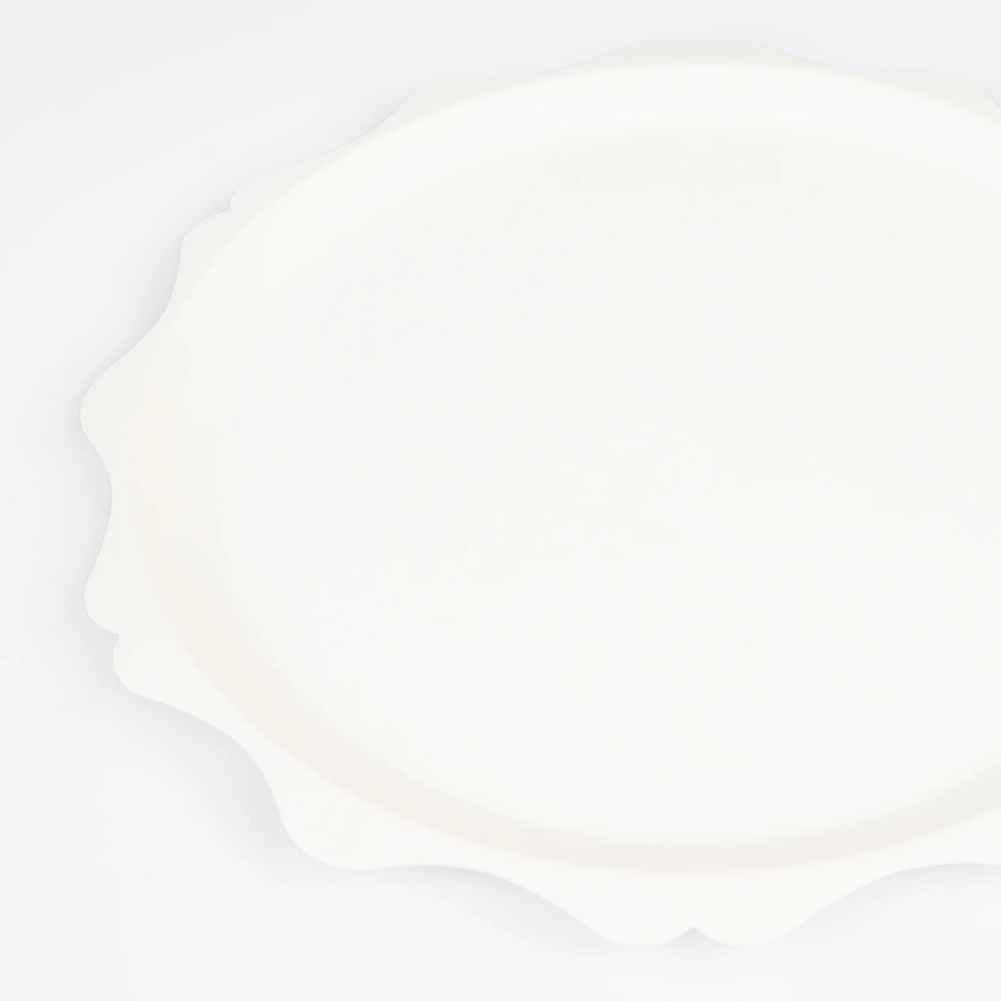 close up of side paper plate in cream colour with decorative scalloped edge