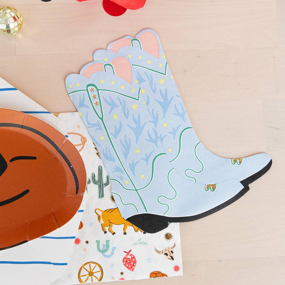 Western kidsβ birthday party tablescape with cowboy boot napkins and themed paper tableware.
