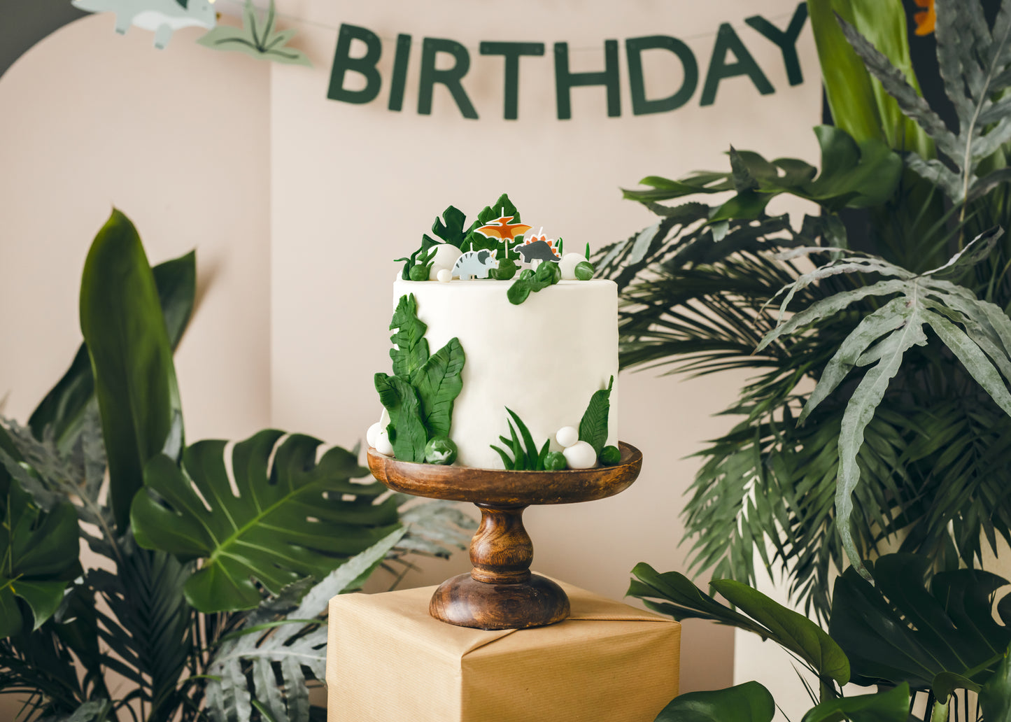 Dinosaur birthday candles styled on a jungle-themed birthday cake available in Toronto and shipping across Canada