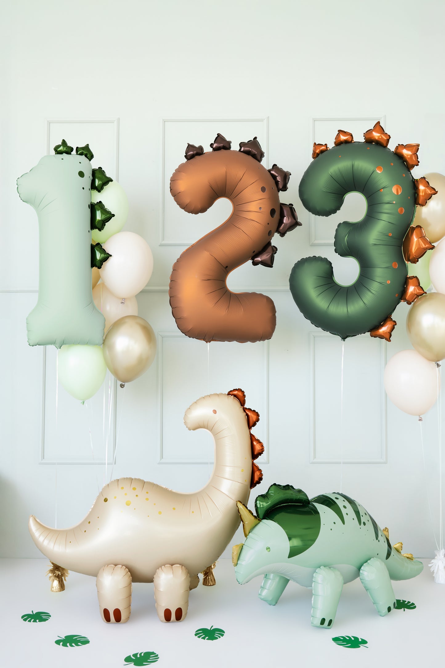 Dinosaur number balloons 1, 2, and 3 in matte tones displayed with dino decor, sold in Toronto at Confetti My Party. Ships across Canada.