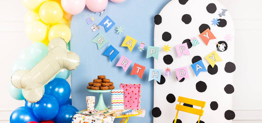 dog themed party supplies with a backdrop & balloons setup