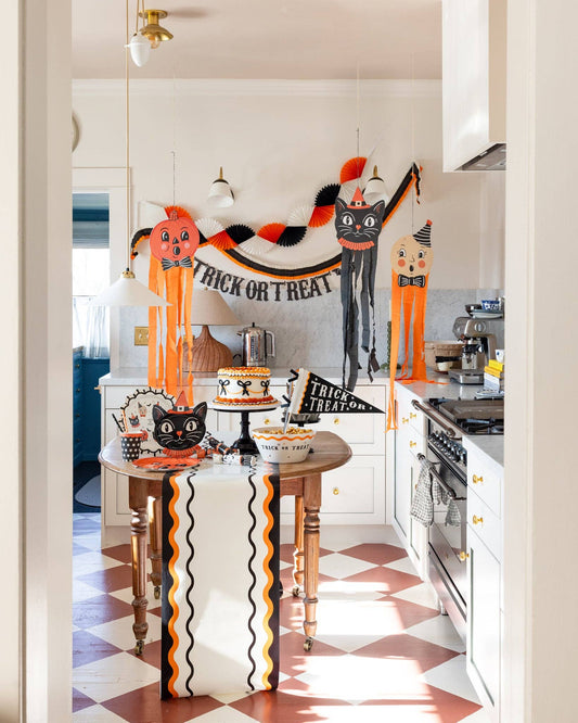 Halloween-themed kitchen with decorative pumpkins and 'Happy Halloween' banner.