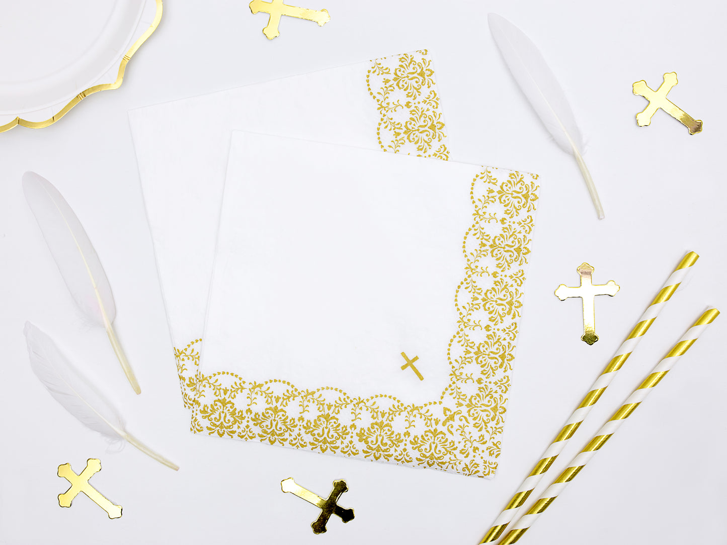 holy communion table set up with cross confetti, gold and white striped straws and gold design cross napkin'