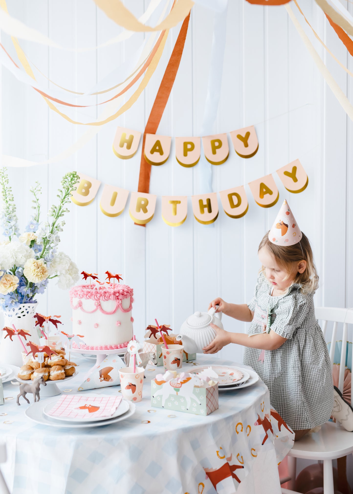 Child wearing a horse party hat at a pastel pony-themed birthday table, available at Confetti My Party Toronto.