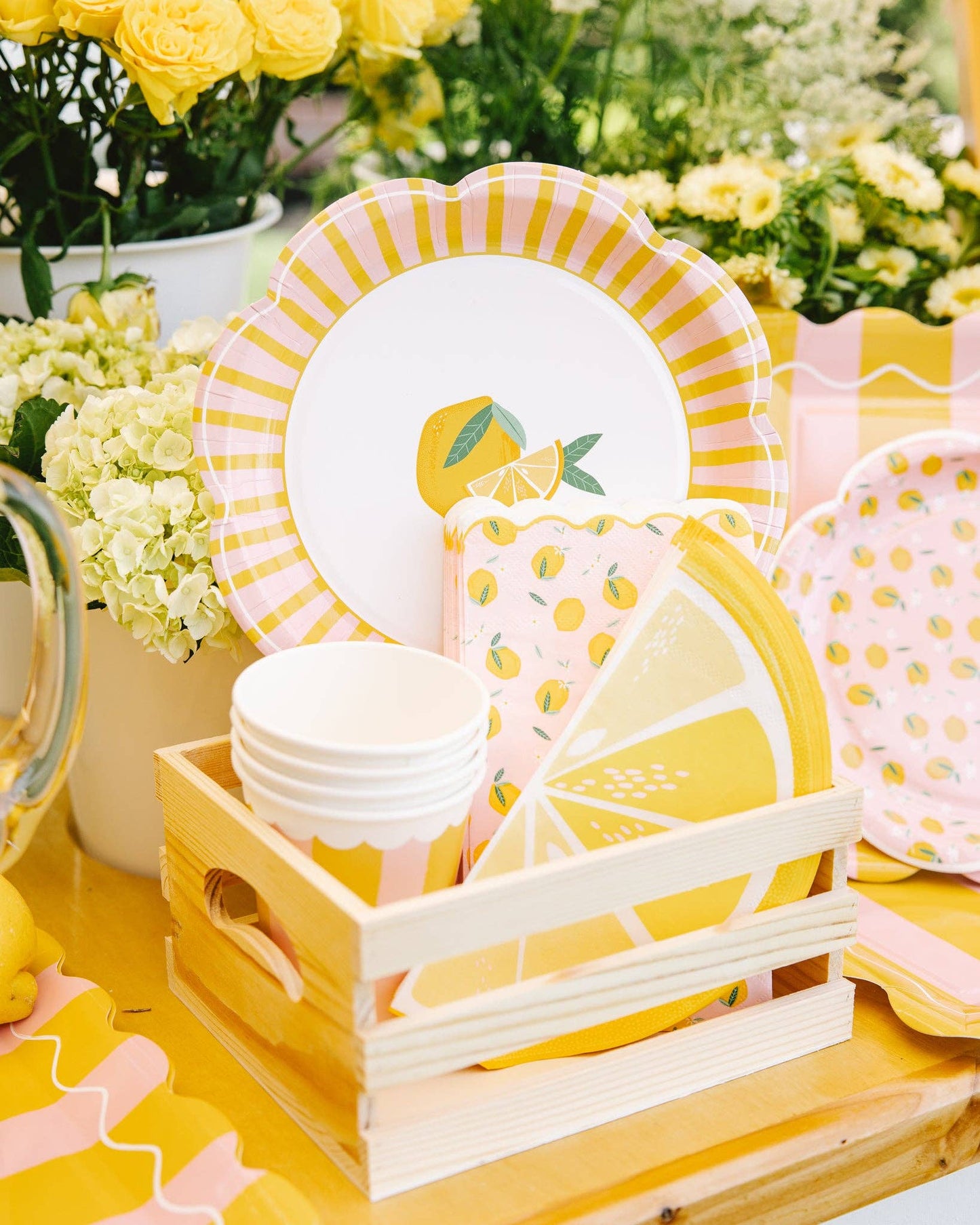 Toronto summer table setup with lemon scalloped plates, striped cups, and floral décor for a cheerful citrus-themed party.