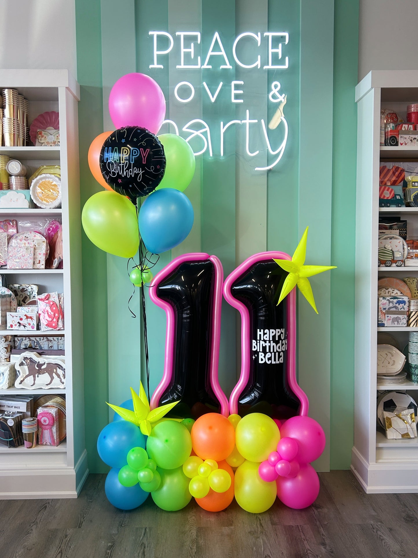 neon balloon structure with a personalized message paired with a matching helium balloon bundle.