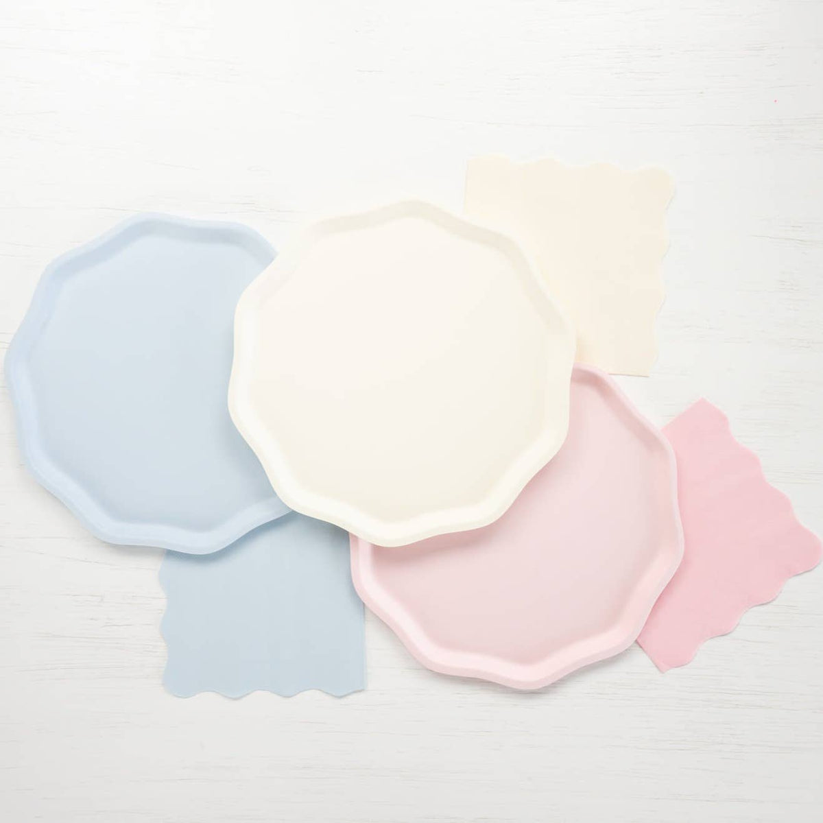 Petal pink scalloped napkins styled with pastel pink, blue and cream party plates