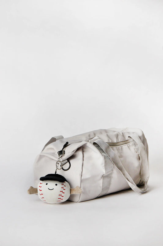 Baseball plush keychain charm clipped onto bag available in Toronto and shipping across Canada