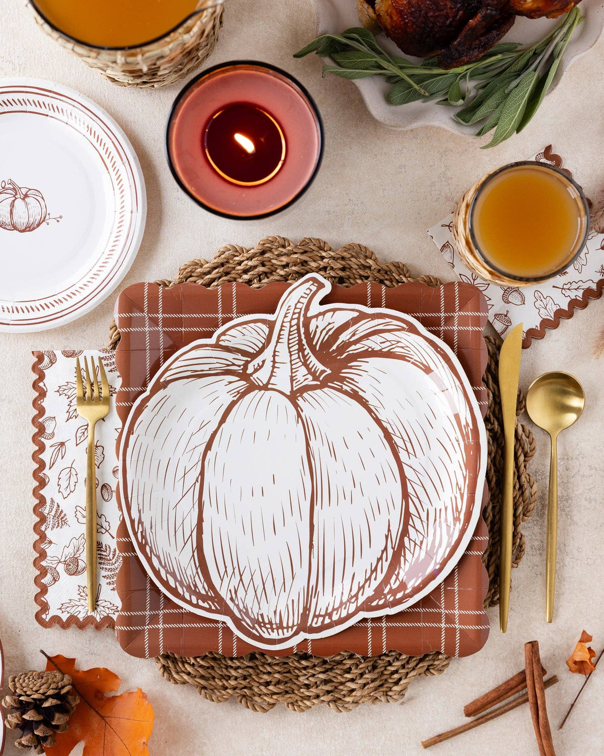 Pumpkin-shaped paper plates styled on a warm Thanksgiving table setting