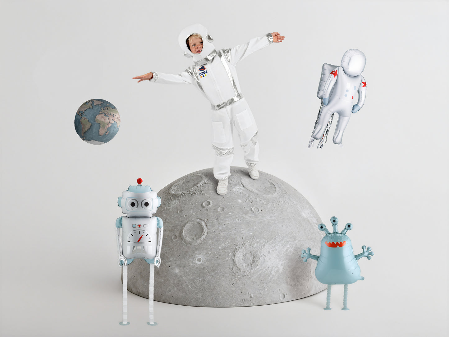 Space-themed balloon party setup with astronaut, robot, and alien balloons styled around a child, available at our Toronto party shop.