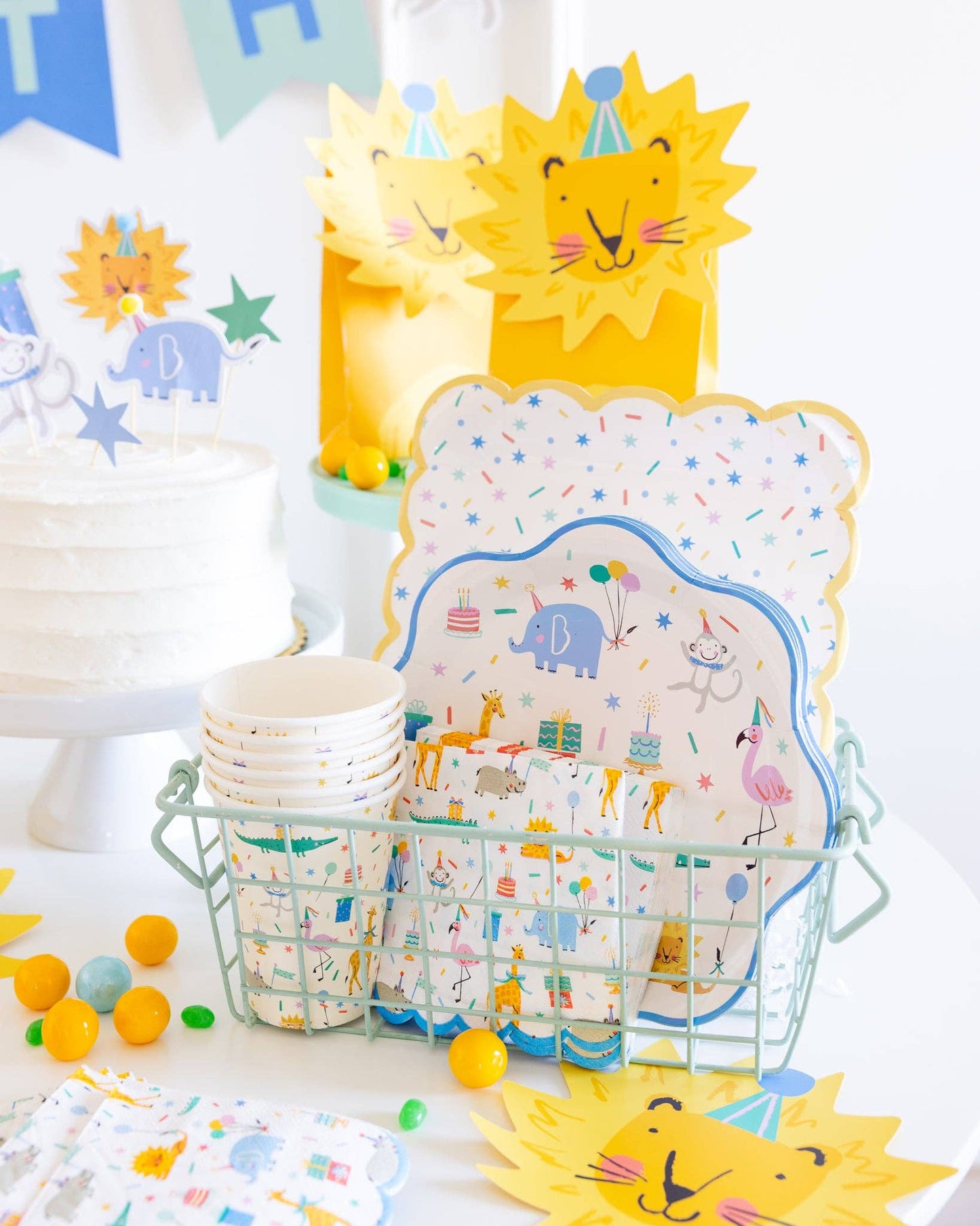 Party table setup with sprinkle-themed plates, cups, napkins, and lion decorations for Toronto celebrations.