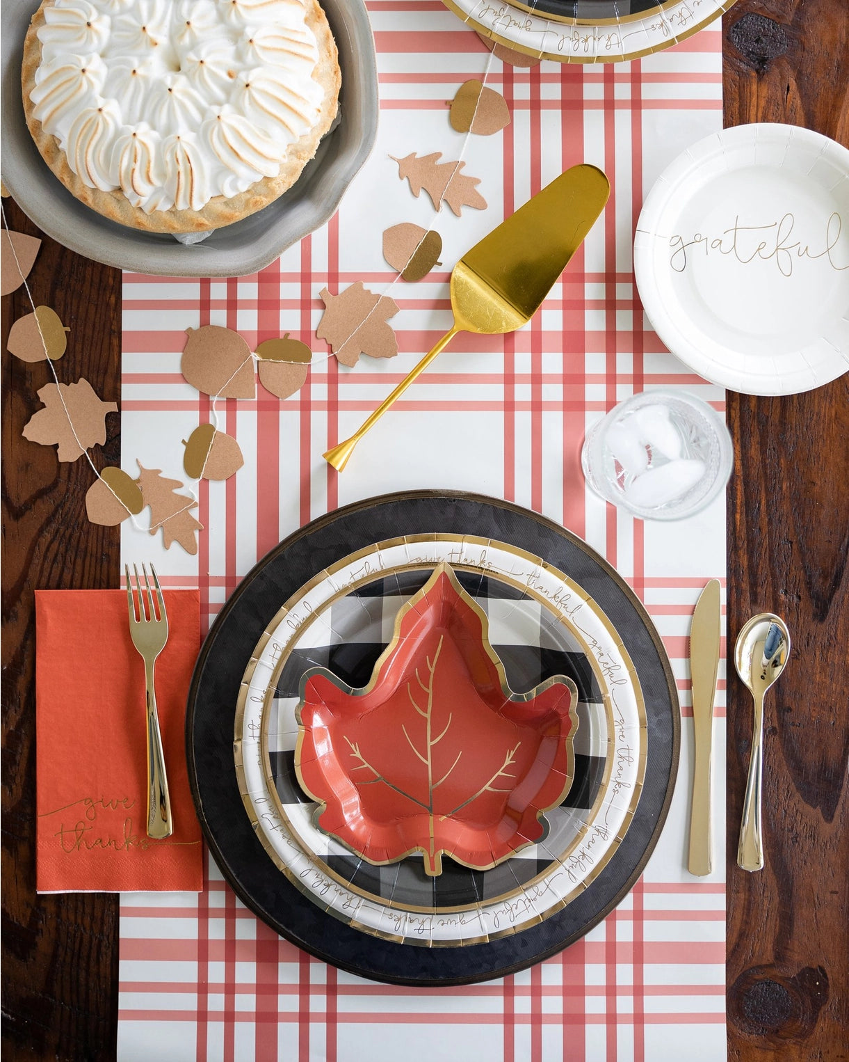 Elegant Thanksgiving table setting with plaid runner, leaf plate, pumpkin pie, and Give Thanks guest napkin.