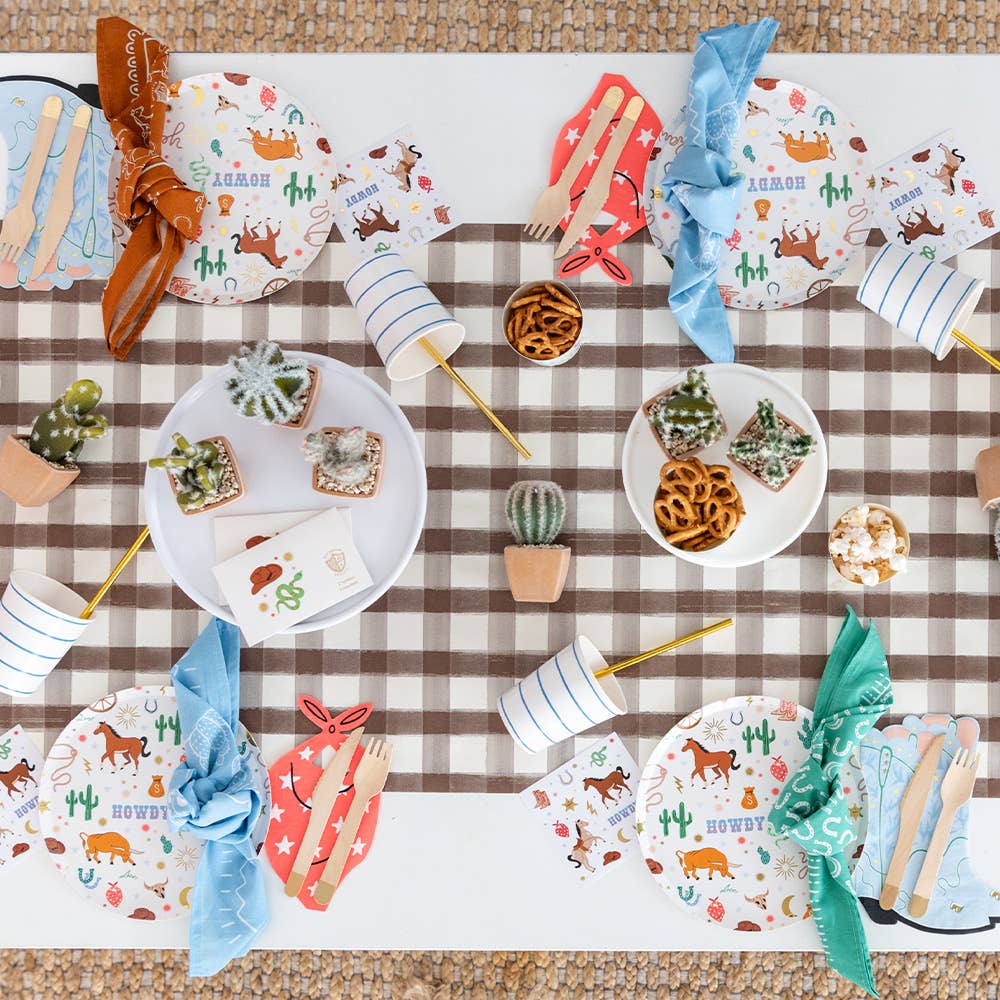 op view of a western party table with cowboy-themed plates, bandana napkins, and decorative accents.