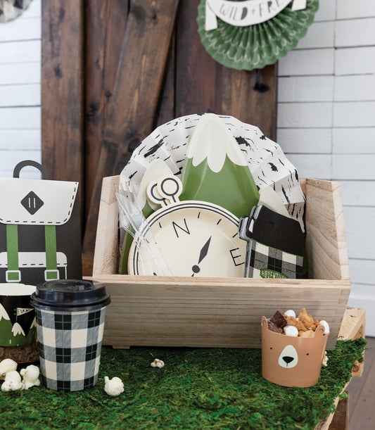 Camping party table with plaid thermos-shaped napkins beside compass plates and wooden decor, styled for events in Toronto and shipping across Canada.