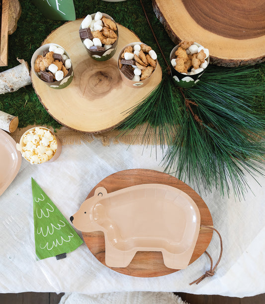 Green tree-shaped napkin styled on a woodland-themed party table with bear-shaped plate in Toronto.