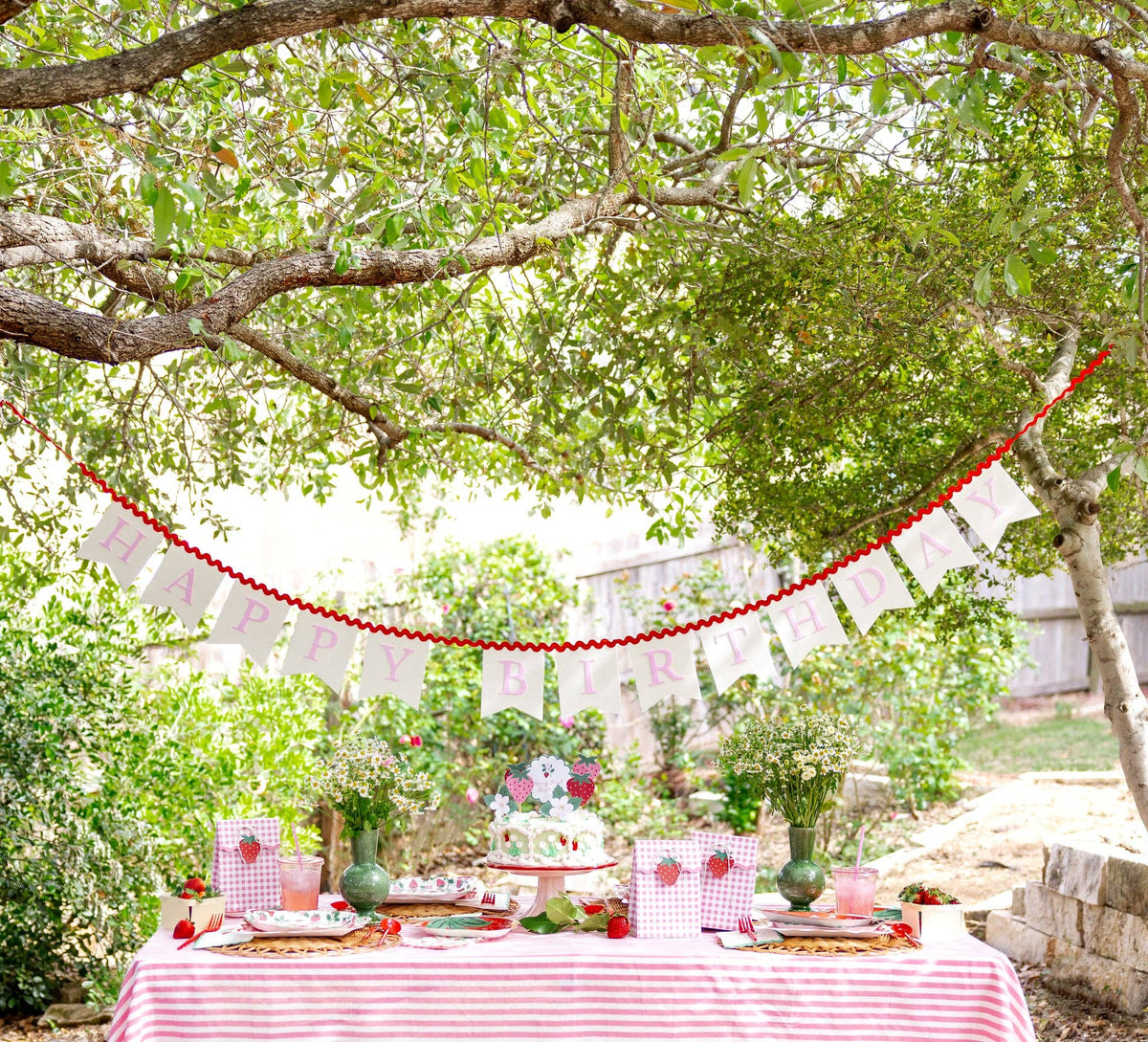 Strawberry themed birthday table with pink and red party decorations