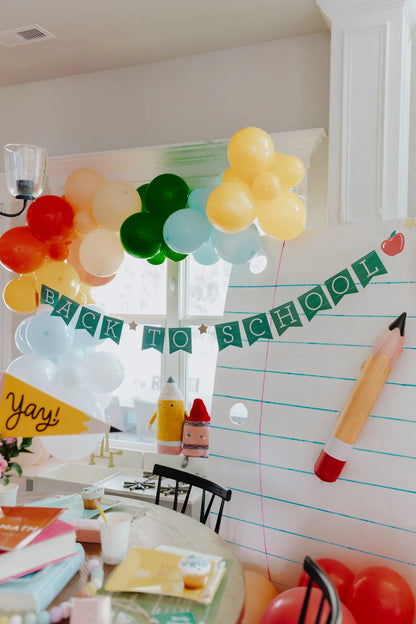Decorated room with 'Back to School' banner, balloons, and a pencil decoration.