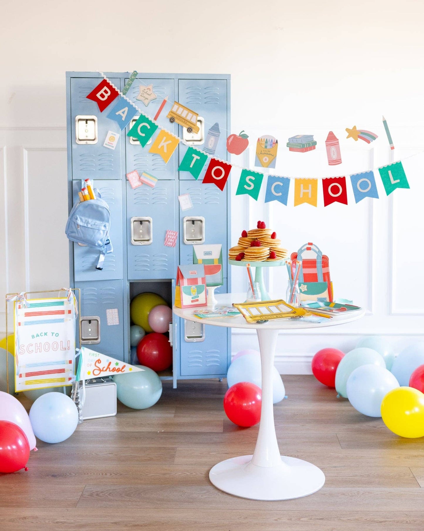 Decorative setup with blue lockers, balloons, and a 'Back to School' banner in a room.