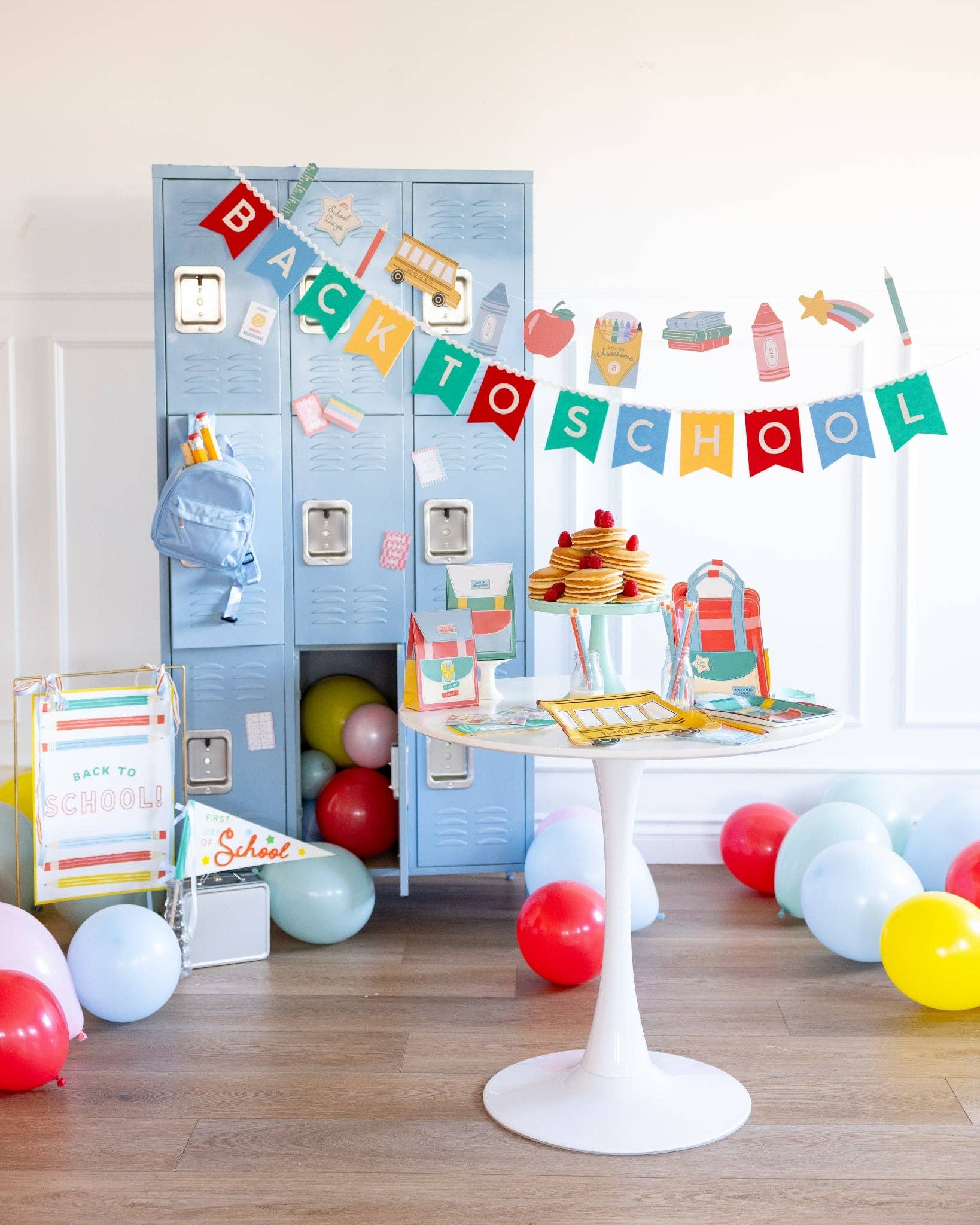 Decorative setup with blue lockers, balloons, and a 'Back to School' banner in a room.