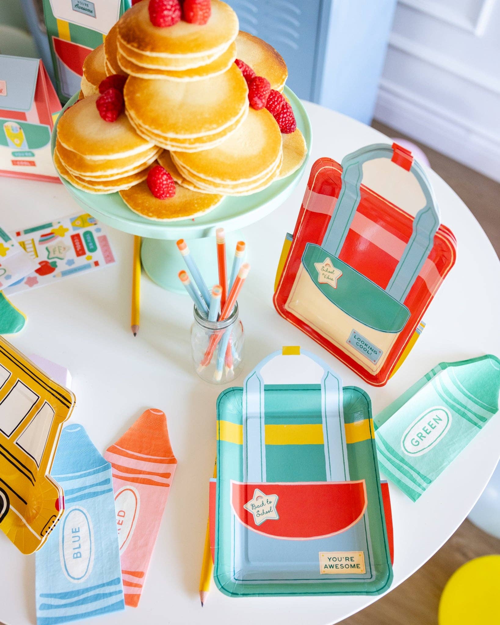 Backpack shaped paper plates styled on a back to school party table with matching school-themed decorations available at our Toronto party shop.