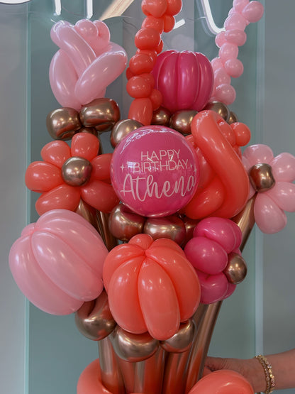 Balloon bouquet with 'Happy Birthday Athena' message against a light blue background