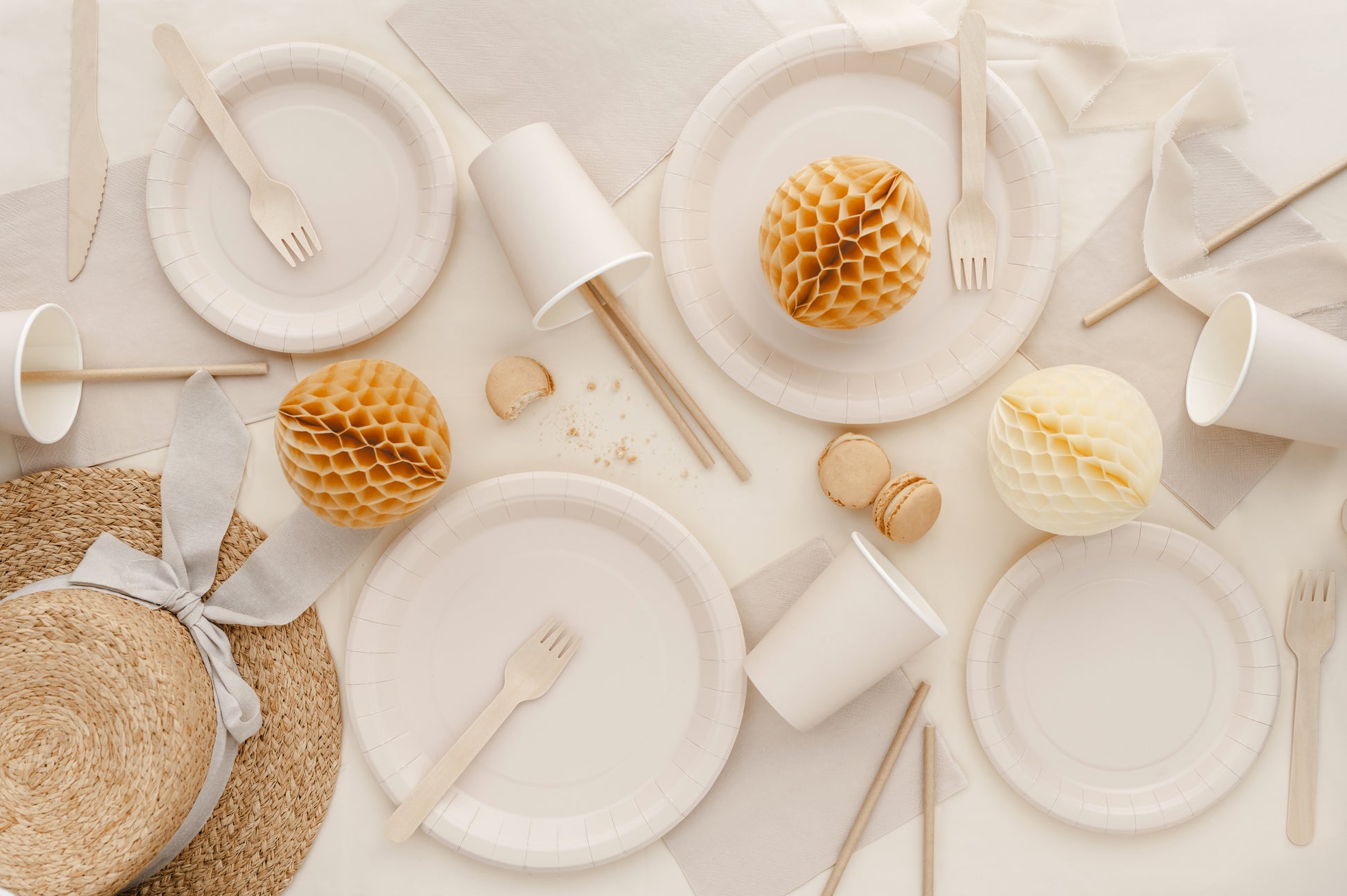 Beige and white table setting with plates, cups, and decorative elements on a light background