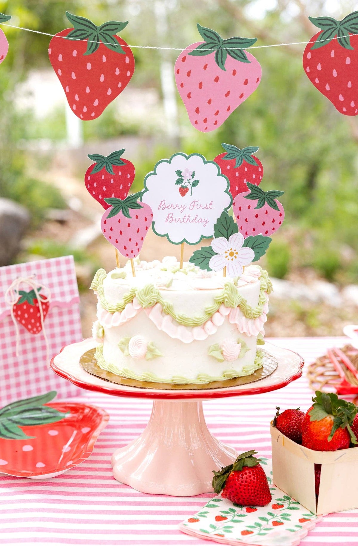 Strawberry Berry First Birthday cake toppers styled on a pink and green birthday cake