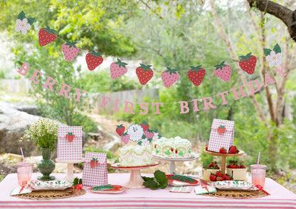 Berry First Birthday strawberry party setup with cake toppers, garland and pink gingham decorations