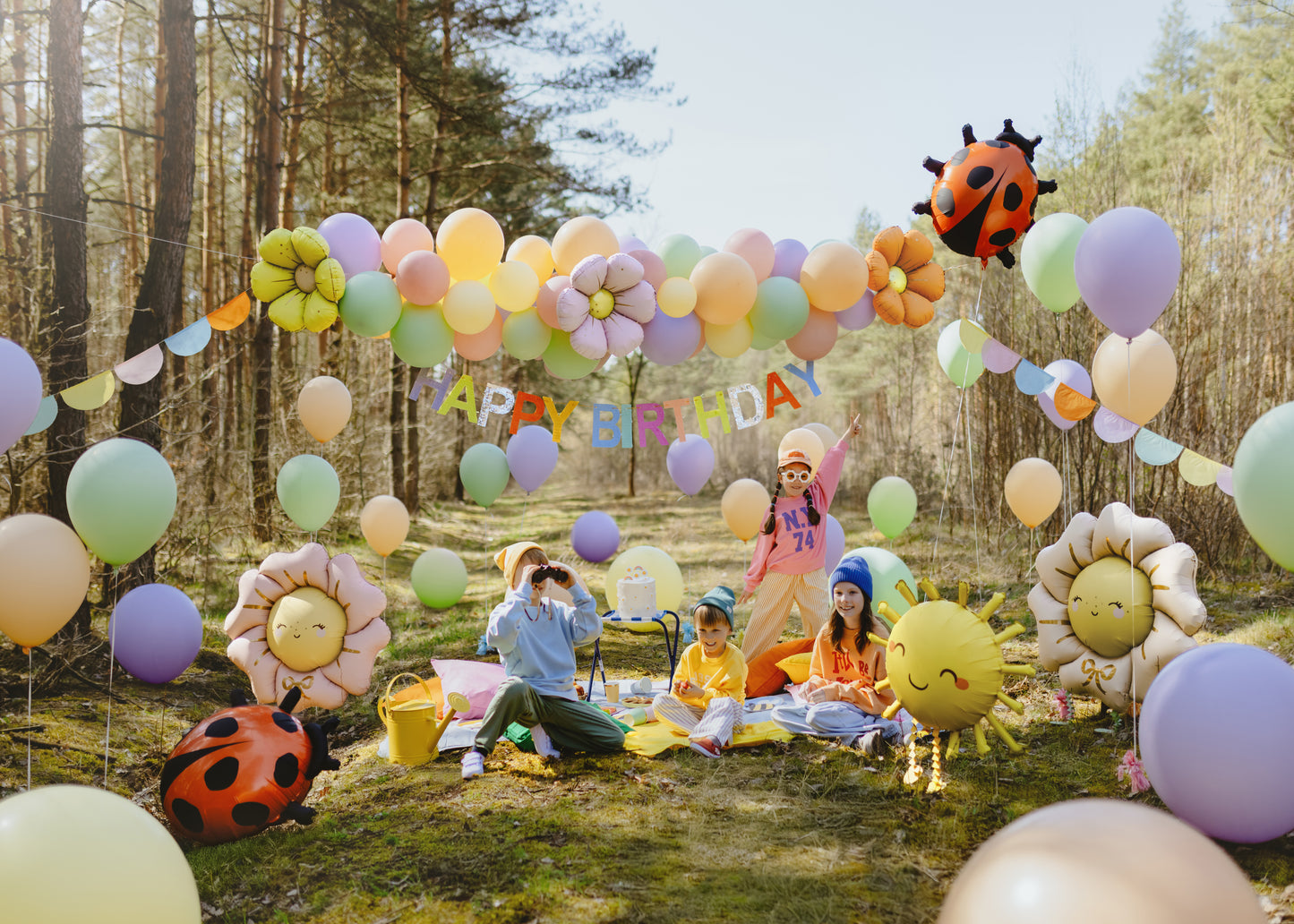 Colourful Happy Birthday banner styled with balloons, outdoor party décor shipping across Canada.