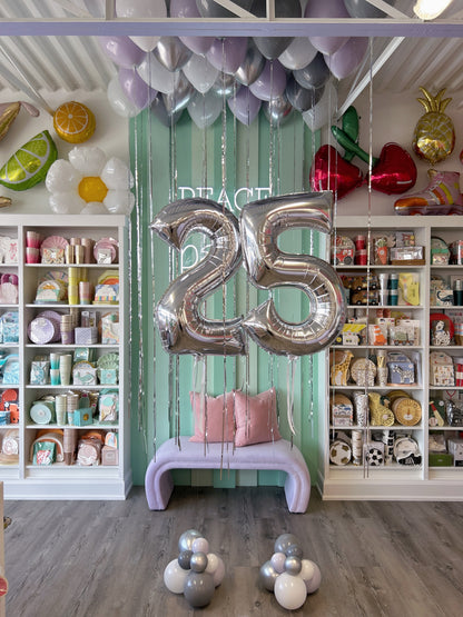 Full birthday balloon display with silver 25 foil numbers, lavender, grey and silver ceiling balloons and matching floor balloon clusters in Toronto.