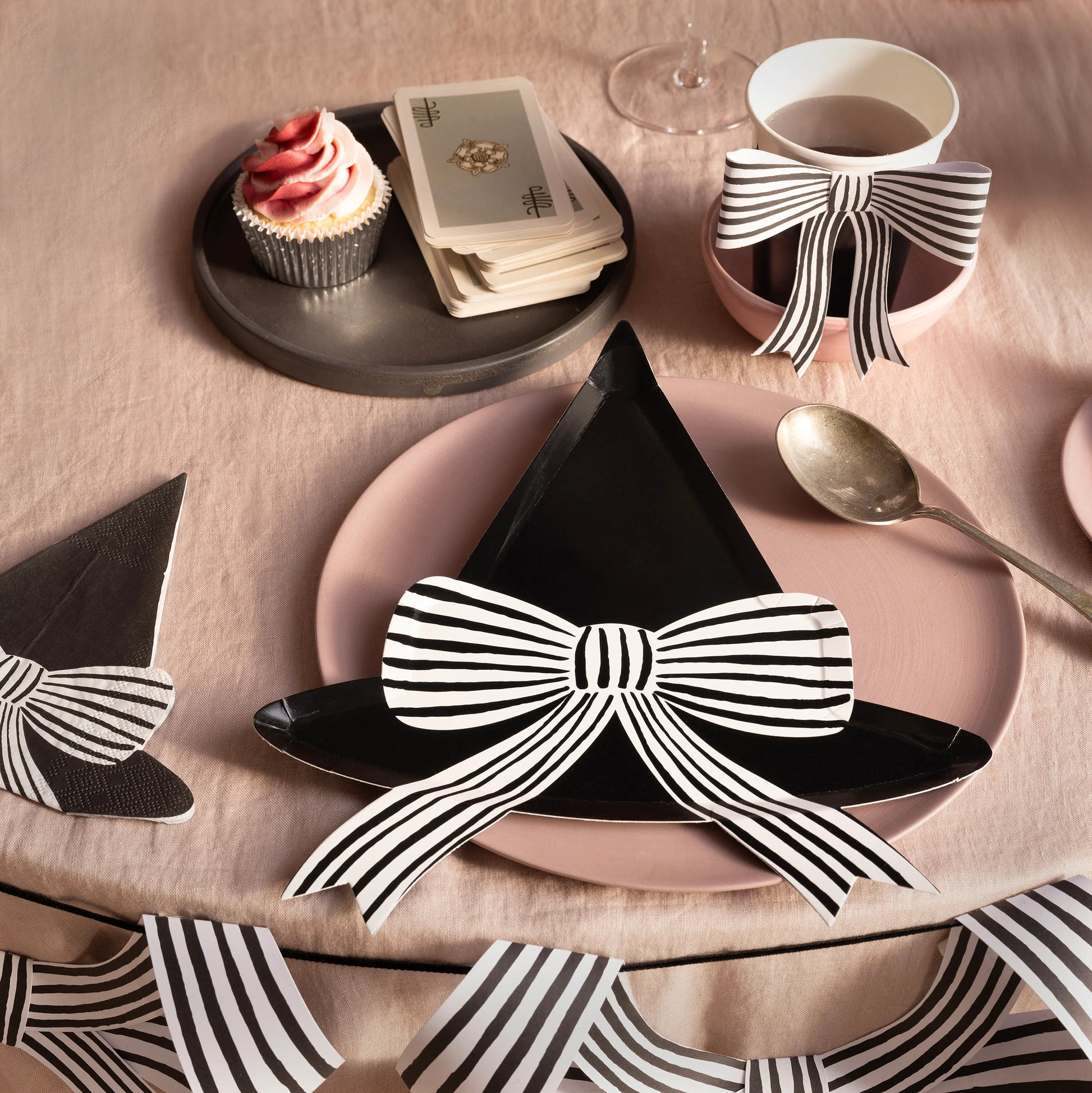 Styled party table featuring striped bow paper cup and witch hat plate, available in Toronto and shipping across Canada.