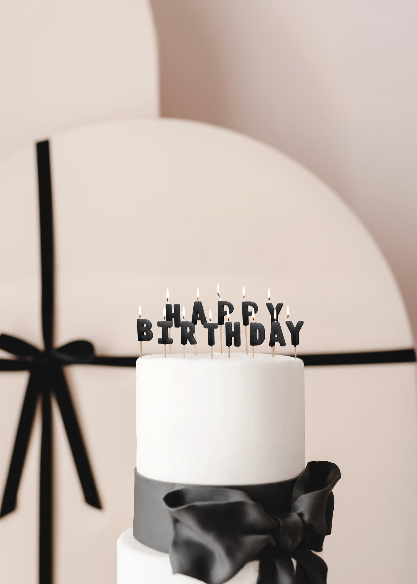 Black Happy Birthday candles styled on a modern birthday cake available at our Toronto party shop