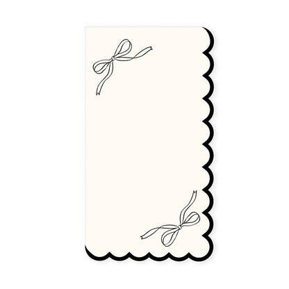 White guest napkin with scalloped edge and black bow details, perfect for elegant bridal showers and parties in Toronto.