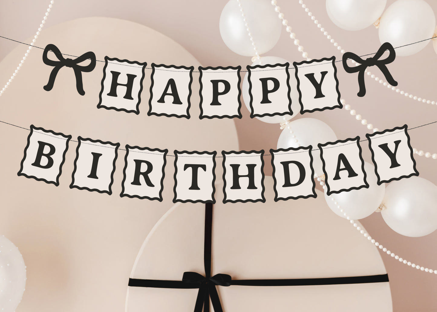 Close-up of black and cream Happy Birthday banner with bow details available at our Toronto party shop