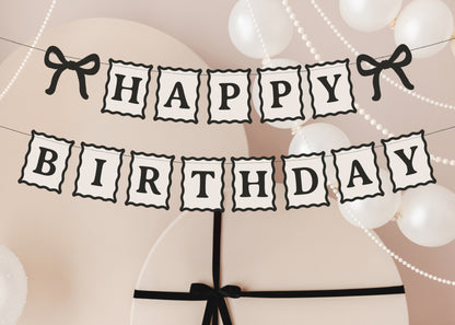 Close-up of black and cream Happy Birthday banner with bow details available at our Toronto party shop
