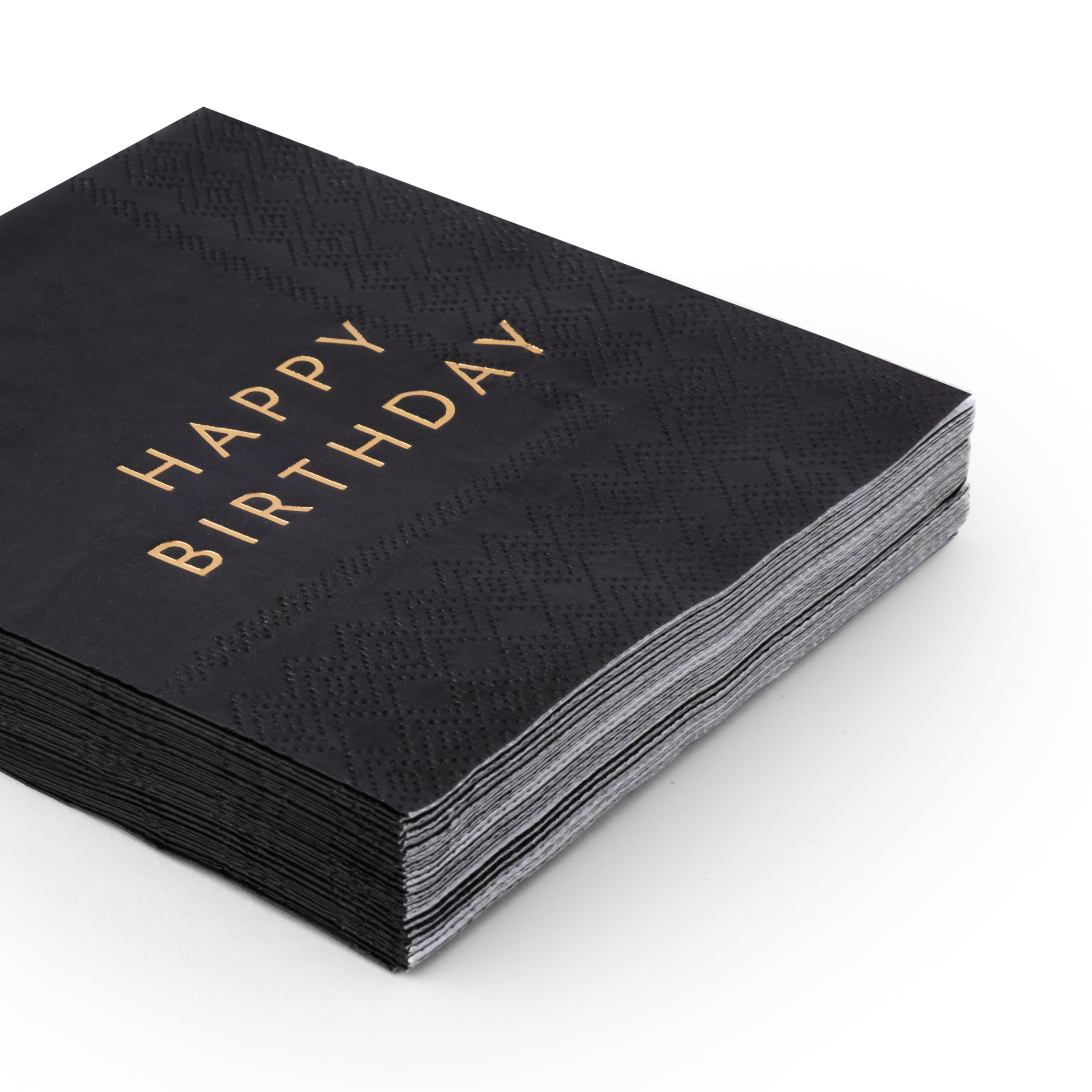 Stack of black Happy Birthday cocktail napkins with gold foil lettering and embossed detail