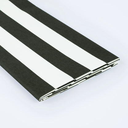 Folded black and white striped tablecloth detail.