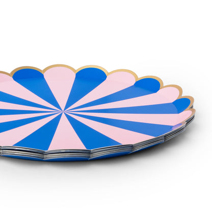 Close-up of blue and pink striped paper party plates with scalloped edges and gold foil trim