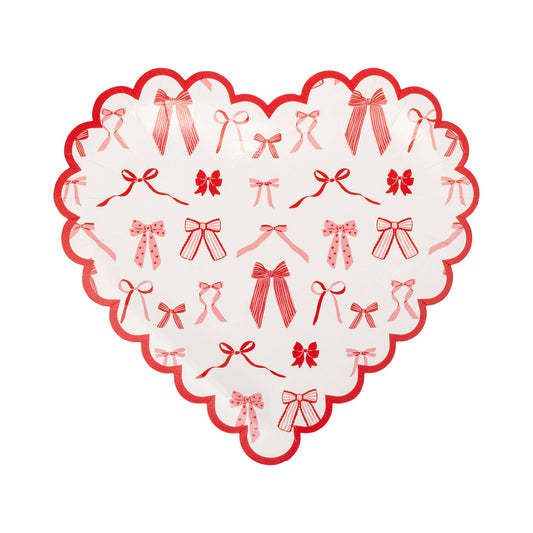 Heart-shaped paper plate with pink and red bow pattern and scalloped edge, sold in Toronto at Confetti My Party