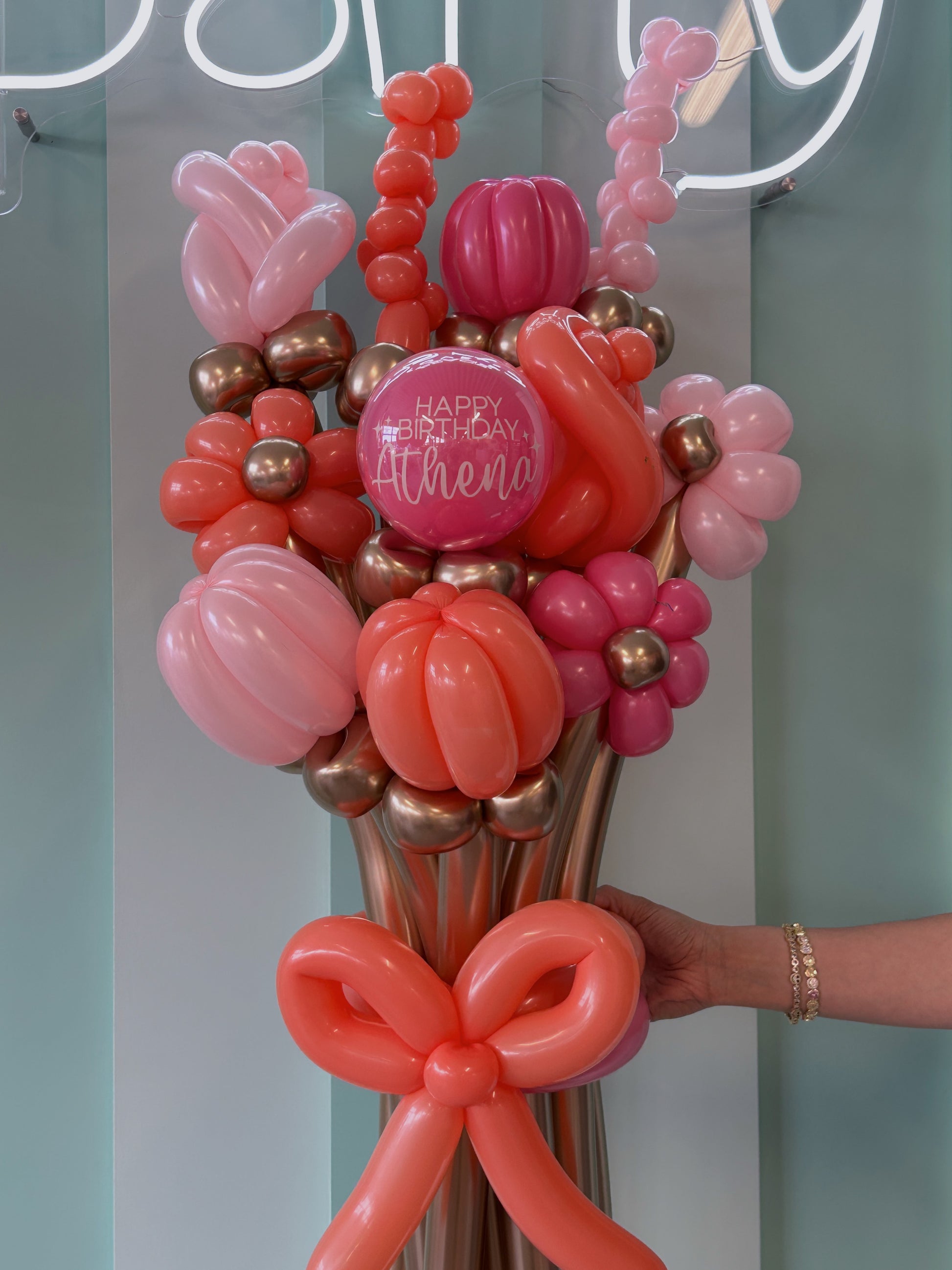 Balloon bouquet with a 'Happy Birthday Athena' message against a light blue background