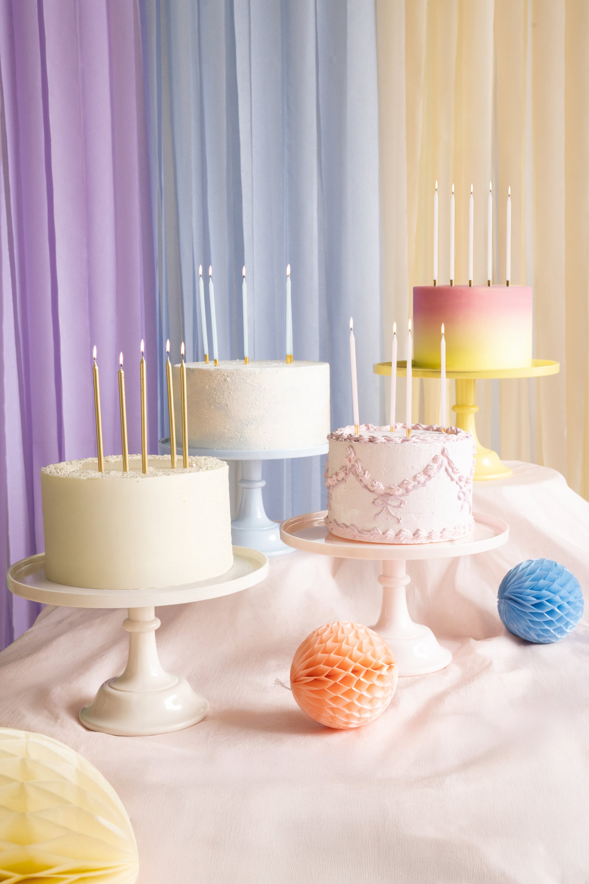Dessert table with yellow, blue, pink and nude cake stands and pastel cakes on display, available in Toronto and ships across Canada.