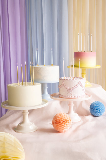 Dessert table with yellow, blue, pink and nude cake stands and pastel cakes on display, available in Toronto and ships across Canada.